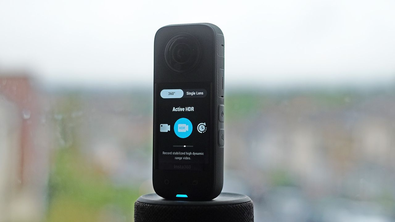 Insta360 X3 on a plynth with blurred cityscape background