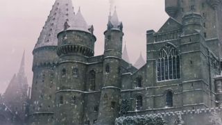 Hogwarts school of witchcraft and wizardy in the Warner Bros movies. It is snowing outside.