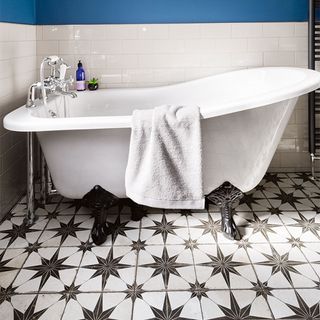 bathroom with white tiled walls and black and white patterned flooring