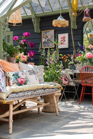 greenhouse used as a pretty outdoor room decorated with vintage style furniture and accessories