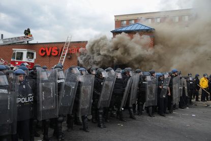 Police guard a CVS that was looted and set on fire.