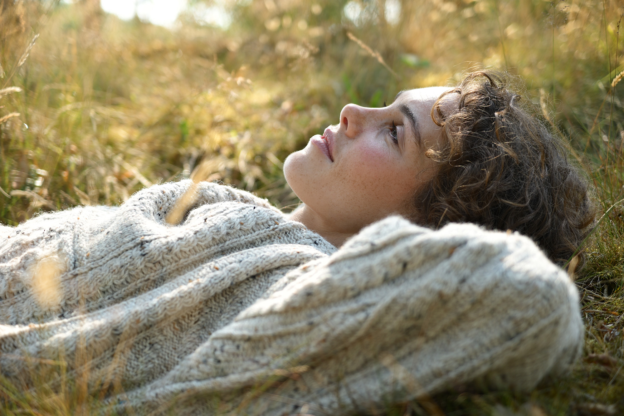 Person lying in grass at golden hour