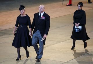 Zara Tindall and her husband Mike Tindall and Princess Eugenie walk as procession with the coffin of Britain's Queen Elizabeth arrives at Westminster Hall from Buckingham Palace for her lying in state on September 14, 2022 in London, United Kingdom. Queen Elizabeth II's coffin is taken in procession on a Gun Carriage of The King's Troop Royal Horse Artillery from Buckingham Palace to Westminster Hall where she will lay in state until the early morning of her funeral. Queen Elizabeth II died at Balmoral Castle in Scotland on September 8, 2022, and is succeeded by her eldest son, King Charles III