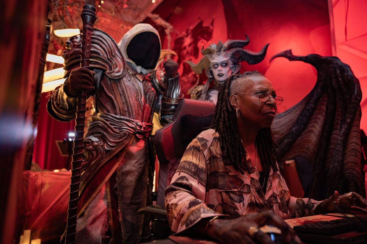 Whoopi Goldberg concentrates on a PC game while Inarius watches over her shoulder.