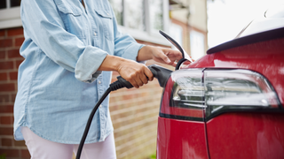 Person holding a charger inside a red car
