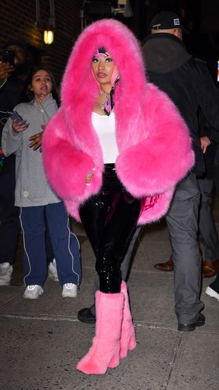Nicki Minaj wearing a hot pink fur coat with matching fur boots