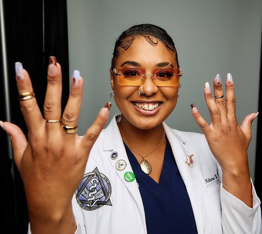 Dr. Natera Wilson showing off her teeth jewelry and wearing a lab coat