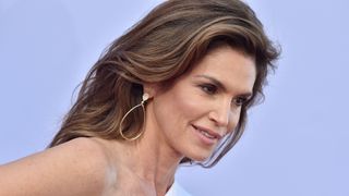 Cindy Crawford now with glowing matte makeup and a white dress