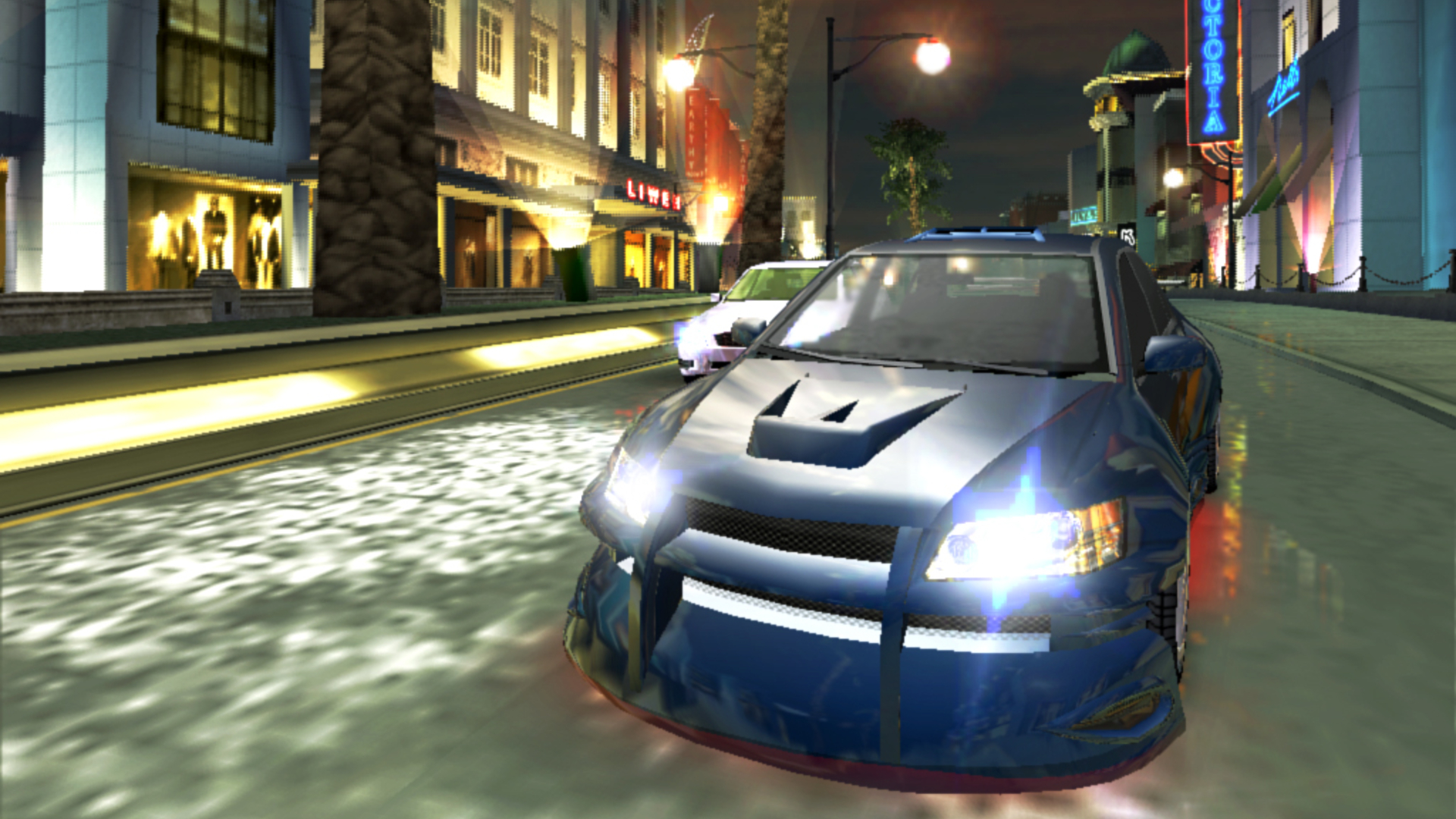 Need For Speed Underground 2 gameplay showing two cars racing neck-and-neck through a quiet coastal city street