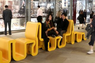mccloy muchemwa bench-Yellow waved/curved seats with people sitting