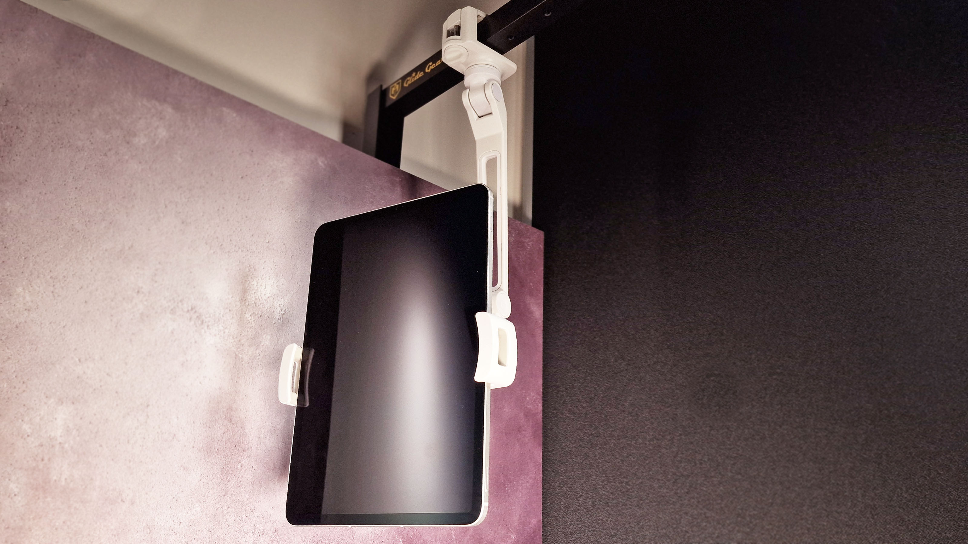 A photo of an iPad in the HoverBar Duo stand attached to a shelf