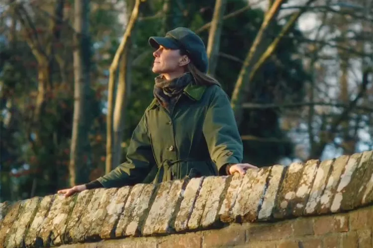 Princess Kate standing on a bridge in a green jacket