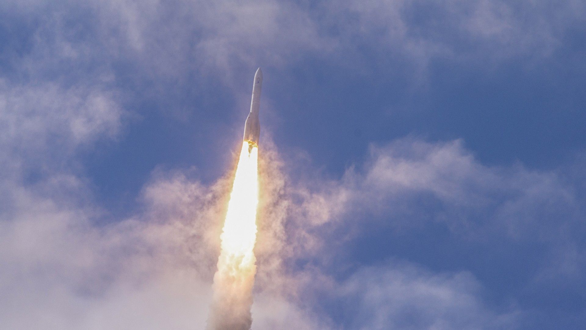 Photo: space.com a large white rocket flies through the sky above a cone of flame