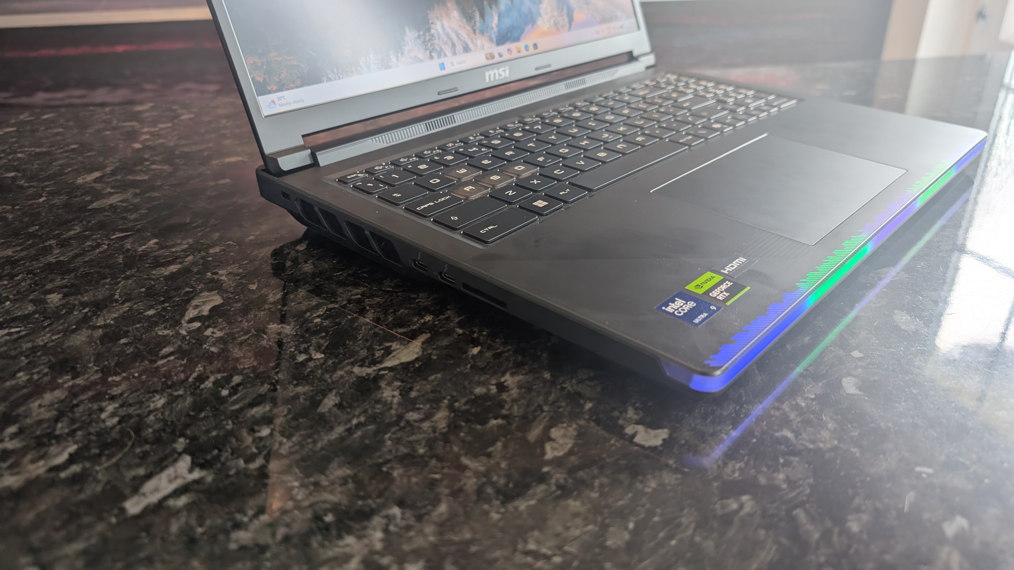 El portátil MSI Raider 16 Max HX fotografiado sobre una encimera de mármol negro.