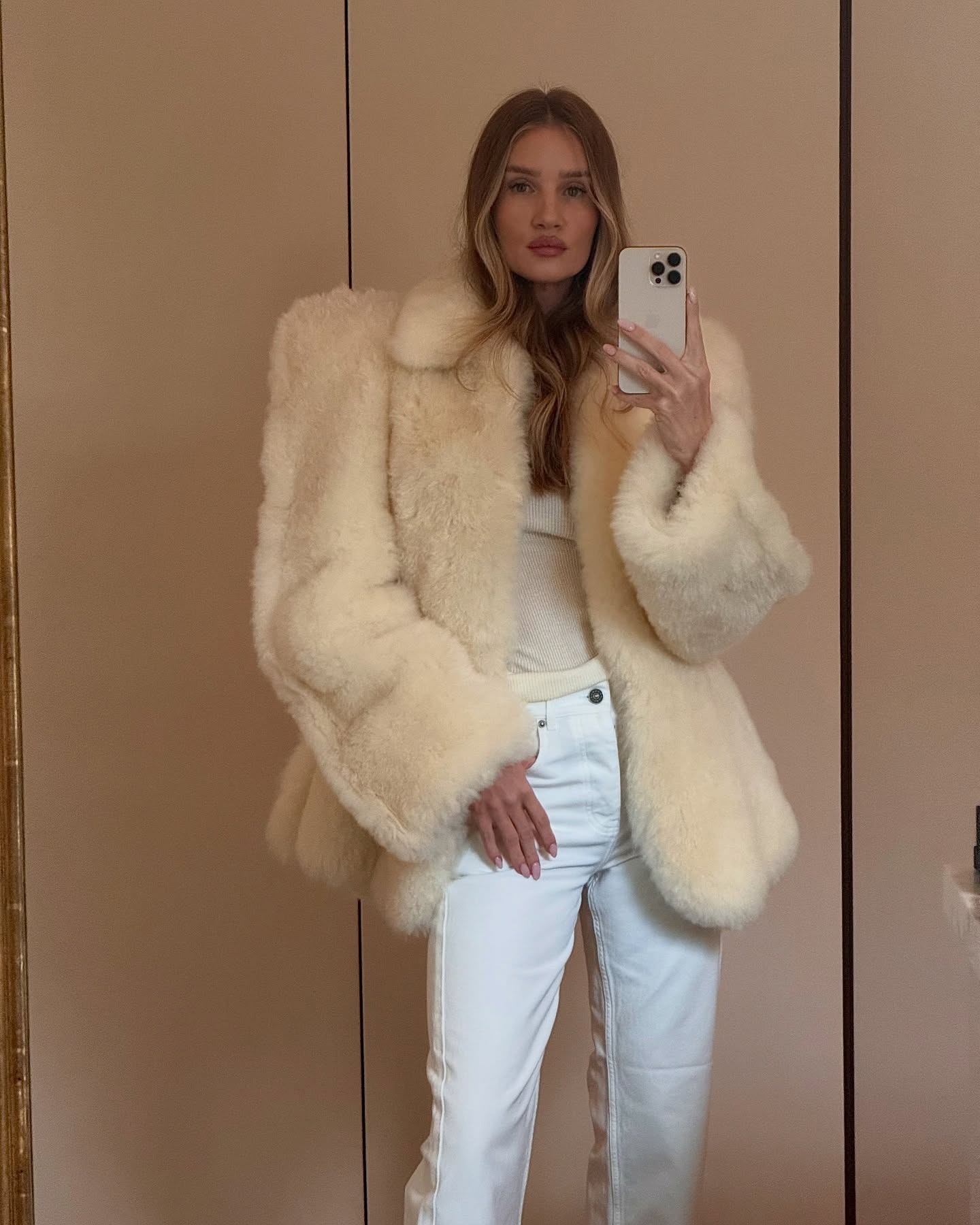 Rosie Huntington-Whiteley wearing a fur coat and white jeans