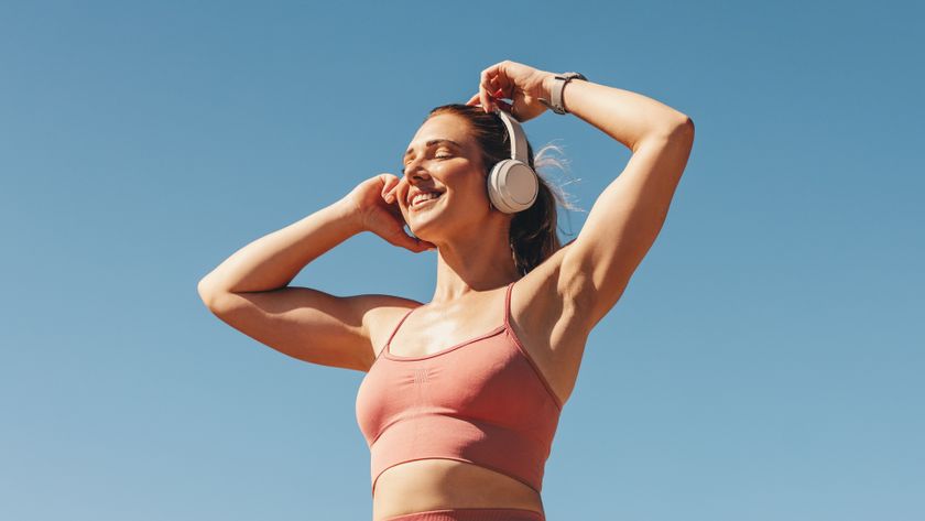 a woman smiling listening to music on headphones