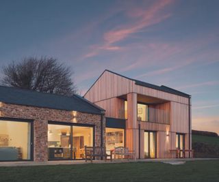 glass link extensions between stone long house and modern timber clad home