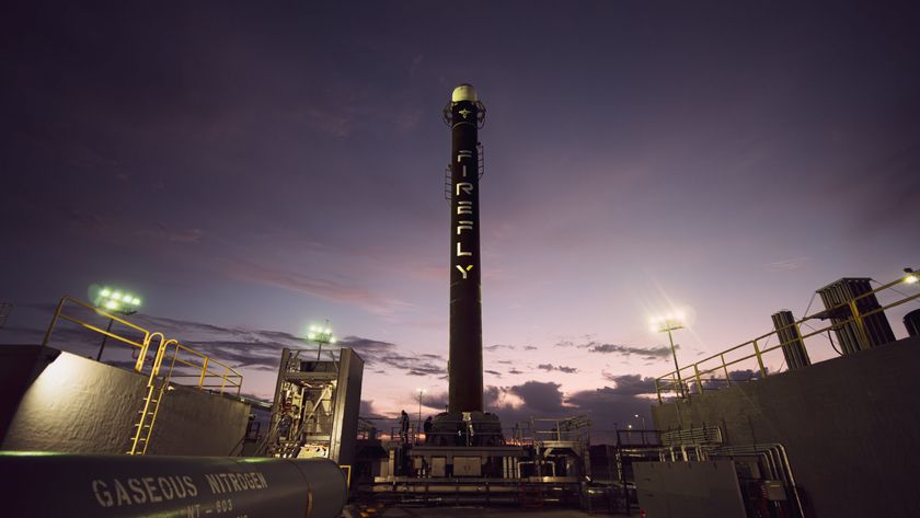 A black rocket stage with white letters stands against a purple sky.