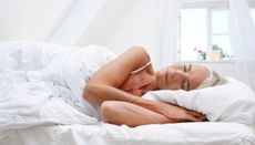 Mature woman sleeping in her bed - stock photo