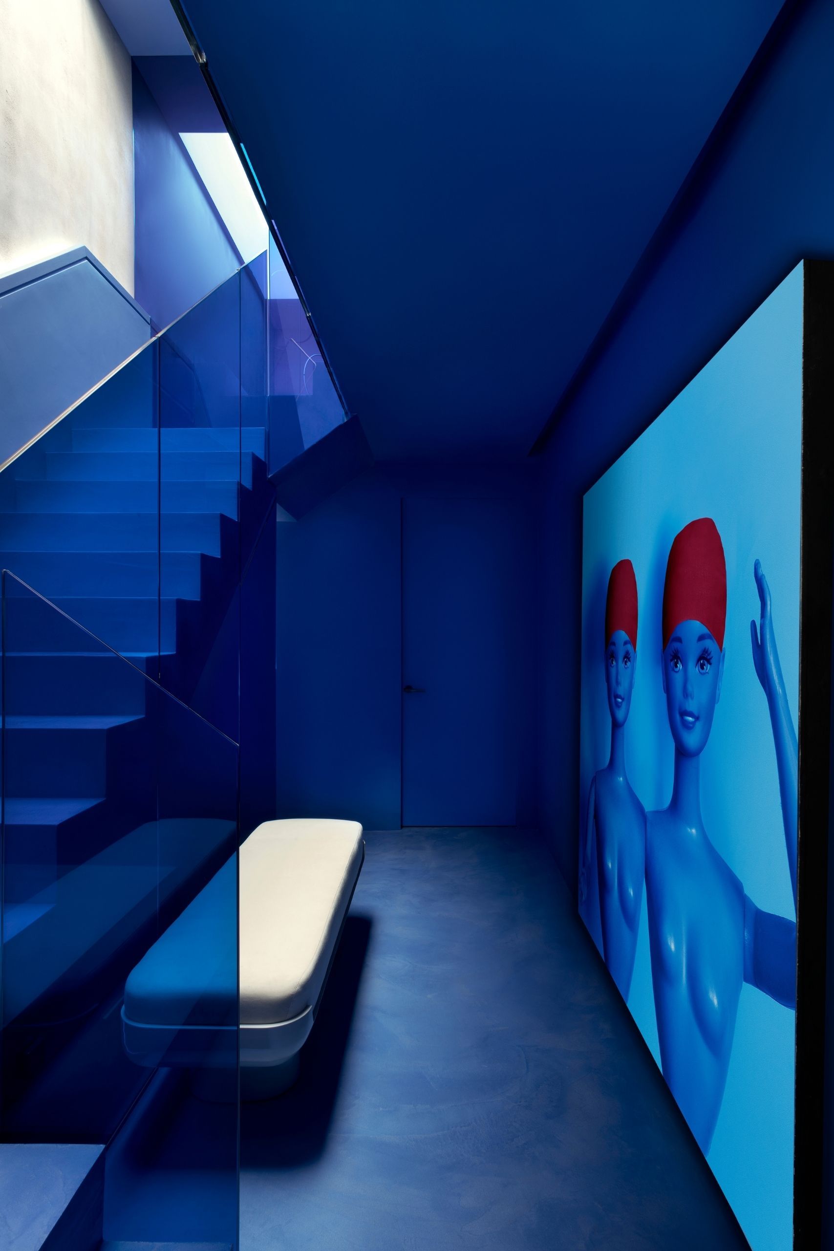 Image of a modern stairwell and hallway completely drenched in a bold cobalt blue.
