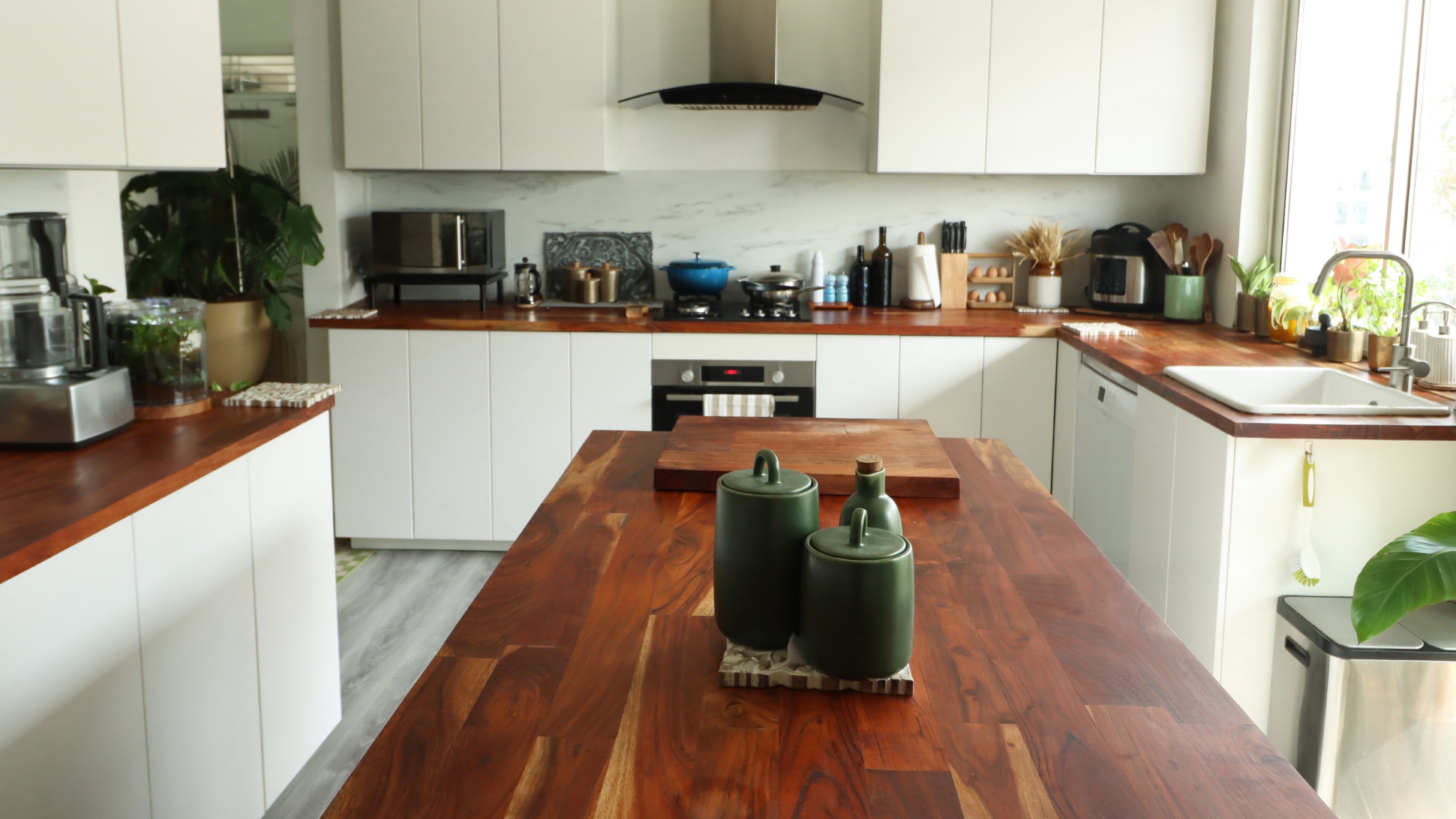 White kitchen with counter-top appliances and wooden worktops
