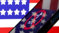  logo of Tiktok is displayed on mobile phone screen in front of flag of United States