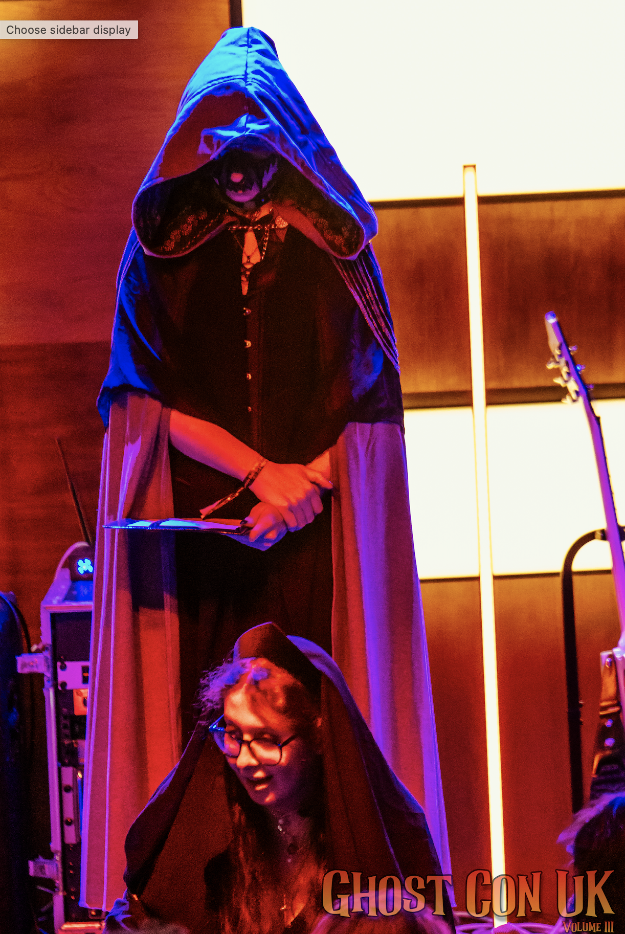 A cloaked person stood on stage during a ritual