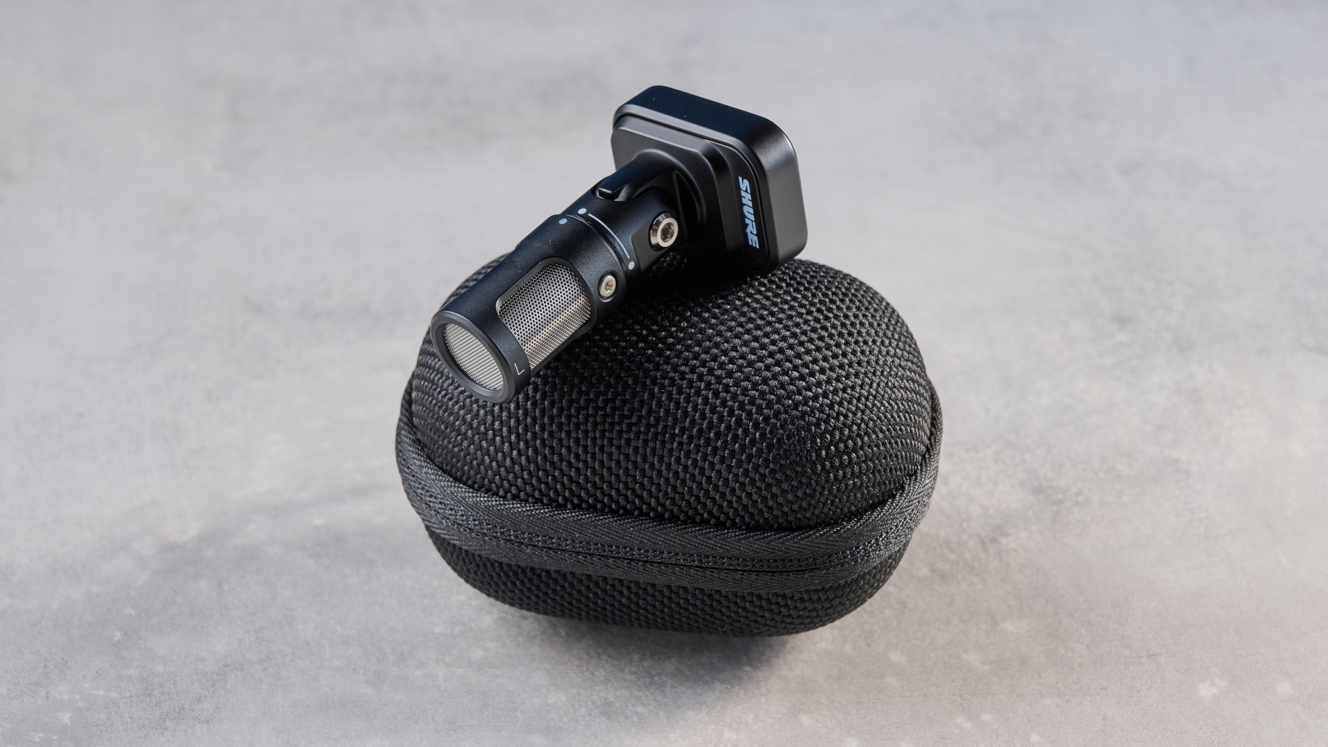 the shure mv88 usb-c microphone photographed against a blue tom's guide background and shown connected to a google pixel 10 pro