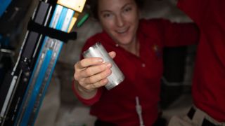 A NASA astronaut holds a water filter in a recycling system on the international space station