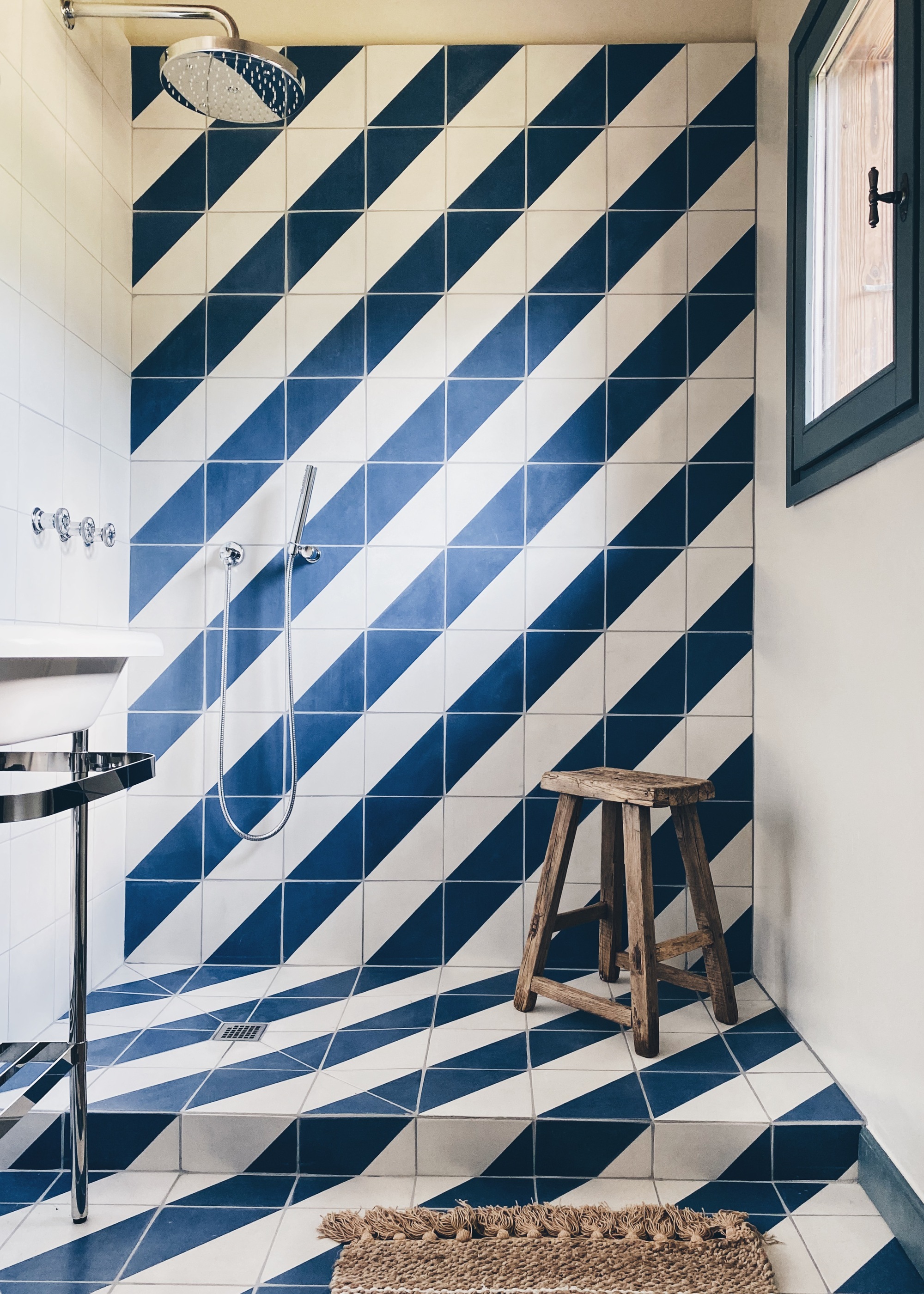 A shower with diagonal blue and white striped tiles