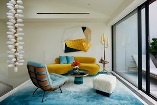 A penthouse sitting room with yellow and blue color palette