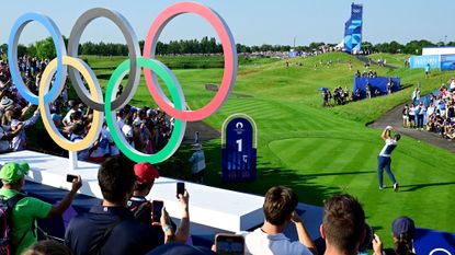 Olympic Golf at Le Golf National in Paris, with the Olympic Rings next a player teeing off