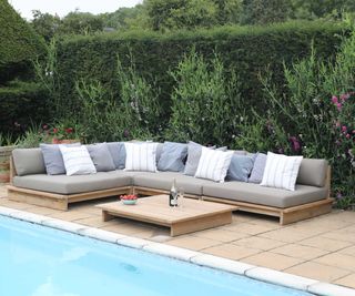 Teak modular sofa by Jo Alexander next to outdoor pool
