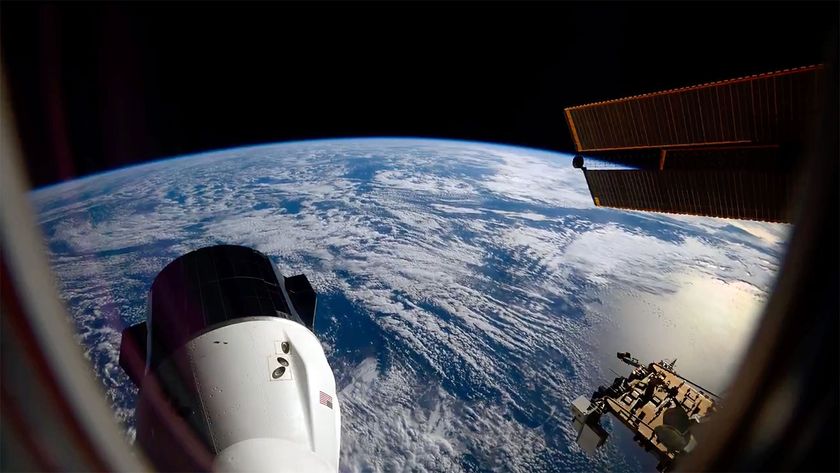 the blue waters and white clouds stretch to out to Earth&#039;s horizon, set against the blackness of space; in the foreground, a space capsule extends out from a space station