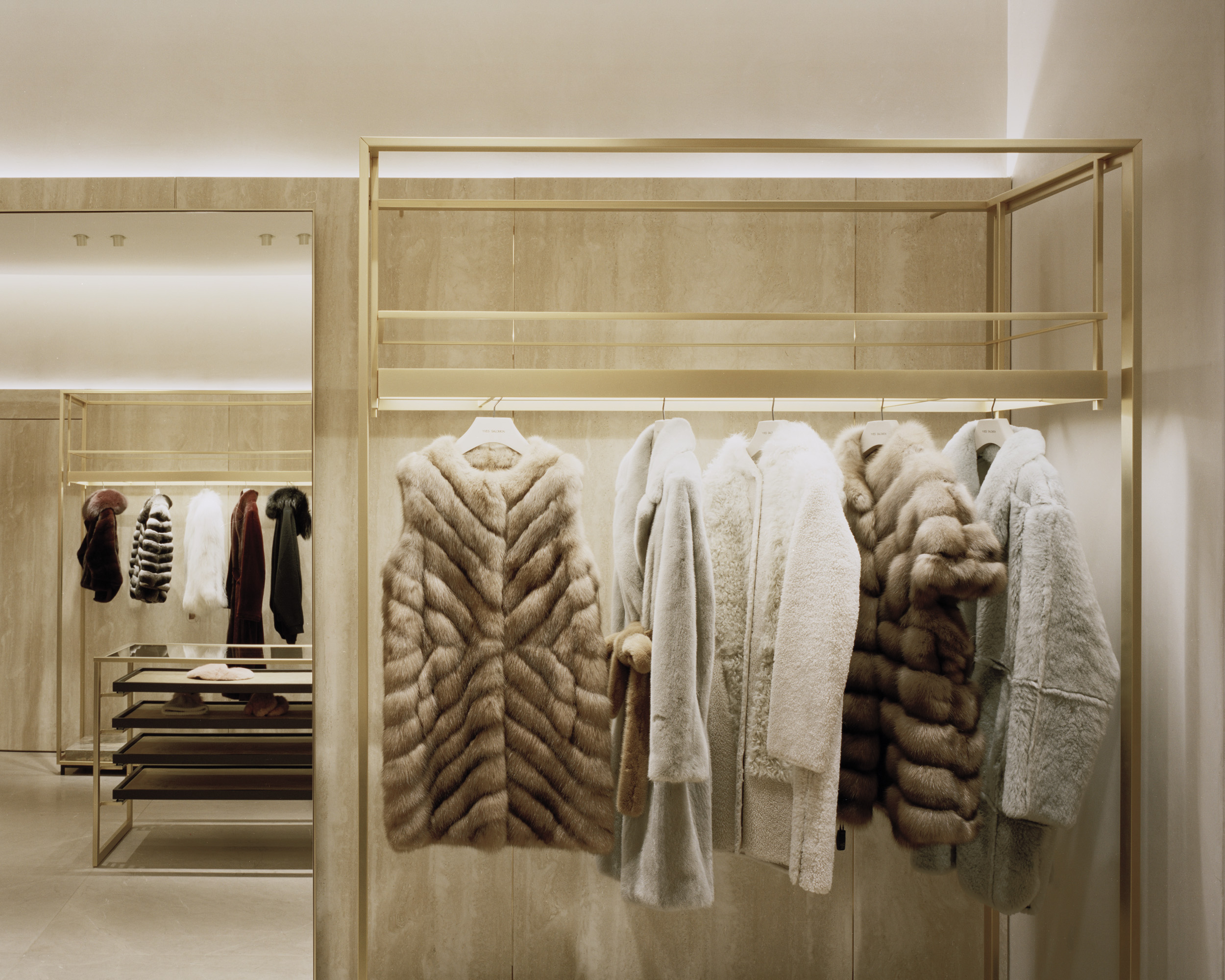Fur coats displayed on a clothing rail in a store