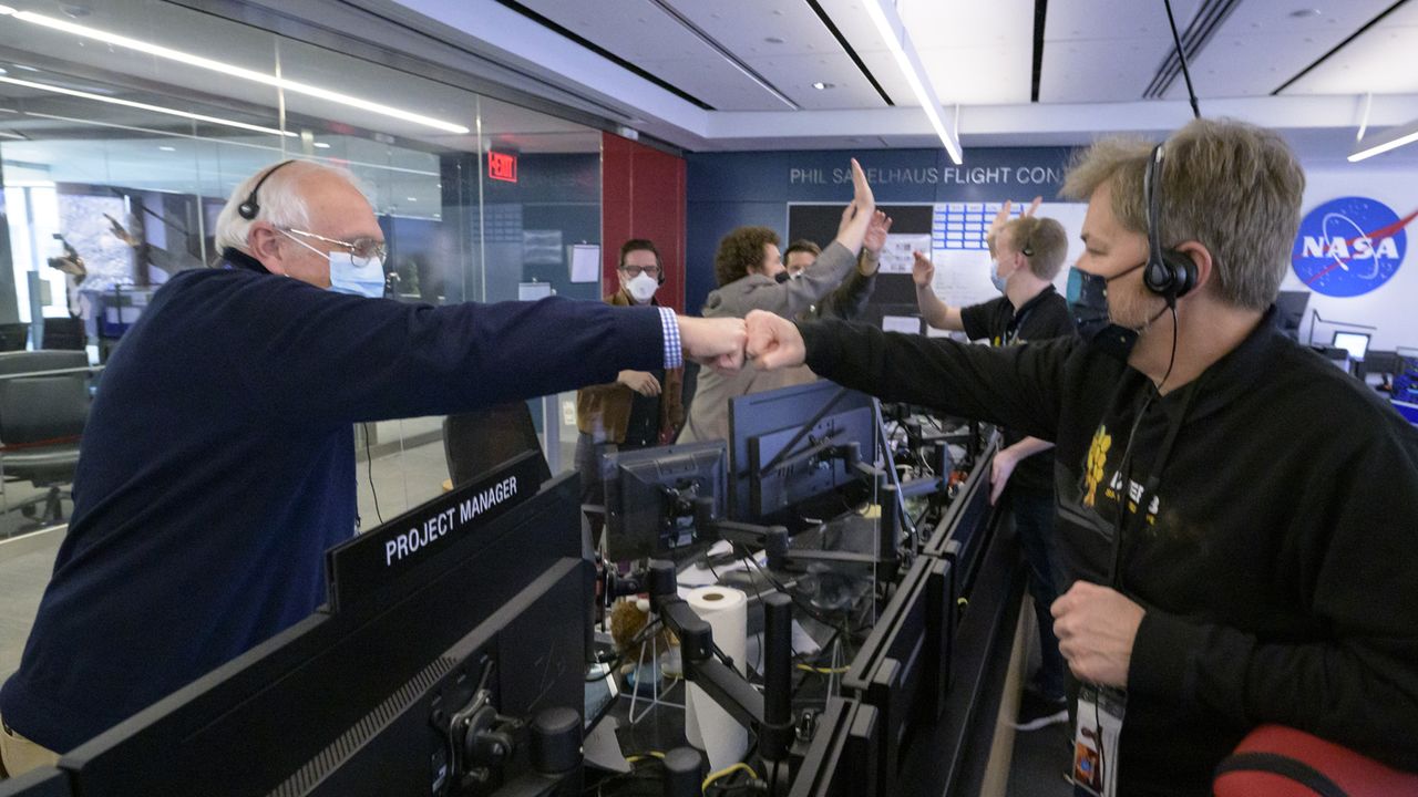 NASA James Webb Space Telescope Project Manager Bill Ochs, left, NASA James Webb Space Telescope Commissioning Manager John Durning, right, and others from the operations team celebrate, Saturday, Jan. 8, 2022, at the Space Telescope Science Institute in Baltimore, after confirming that the observatory&rsquo;s final primary mirror wing successfully extended and locked into place
