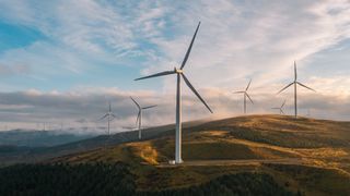 Renewable energy concept image showing photograph of wind turbines on a barren landscape.