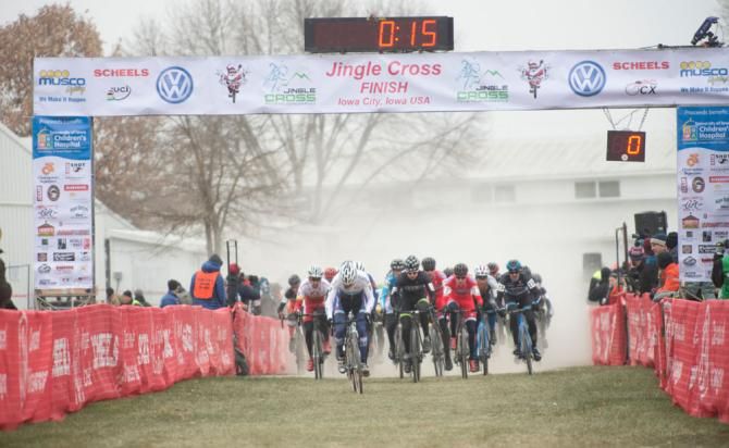The men's field leaves the start area in a cloud of dust