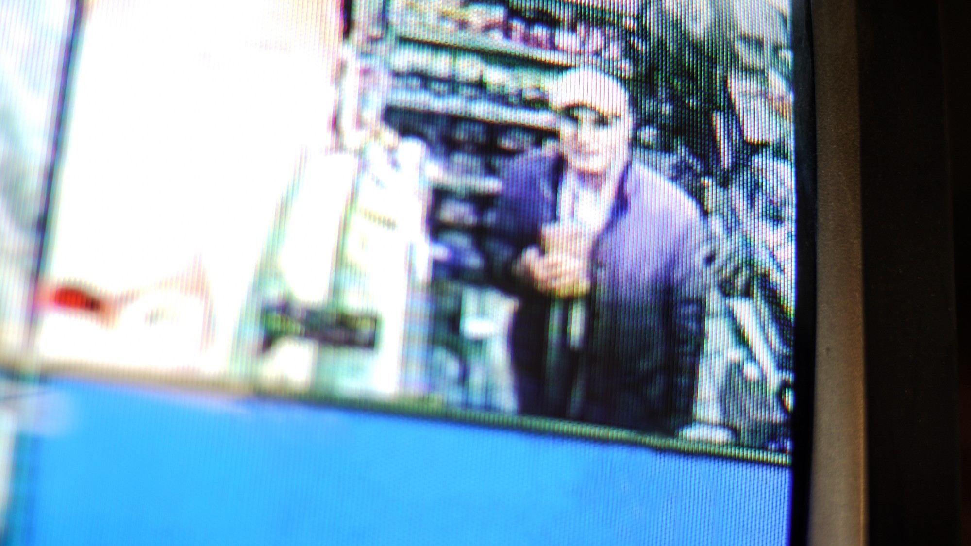 Man holding an item, seen on shop CCTV