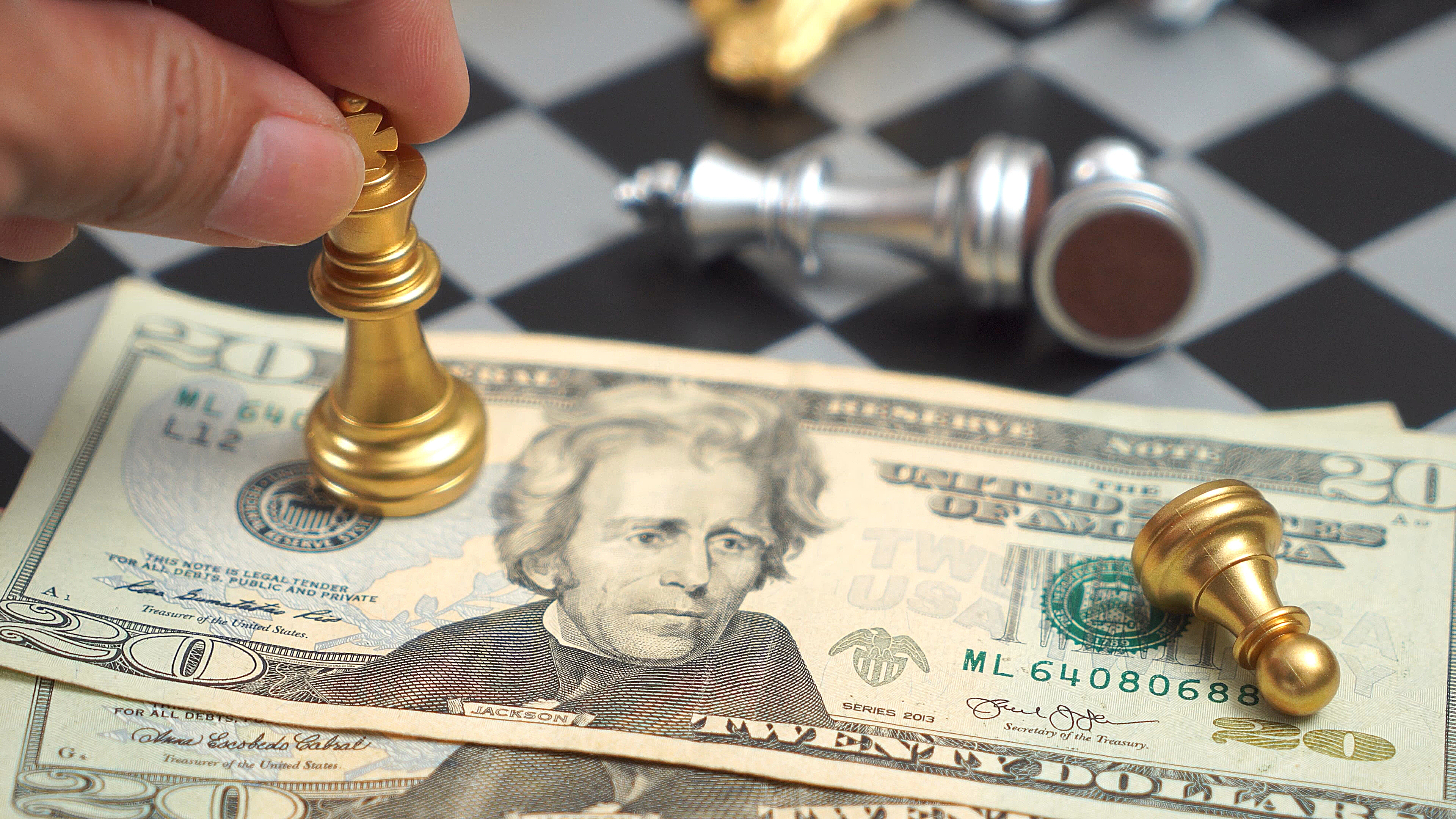 Close-up of chess pieces on a twenty-dollar bill, representing the connection between strategic thinking and financial decision-making.