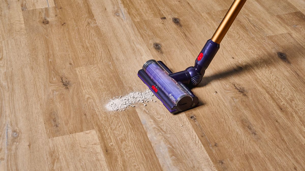 the dyson gen5detect cordless stick vacuum in prussian blue and copper, showing its cleaning head and attachment tools