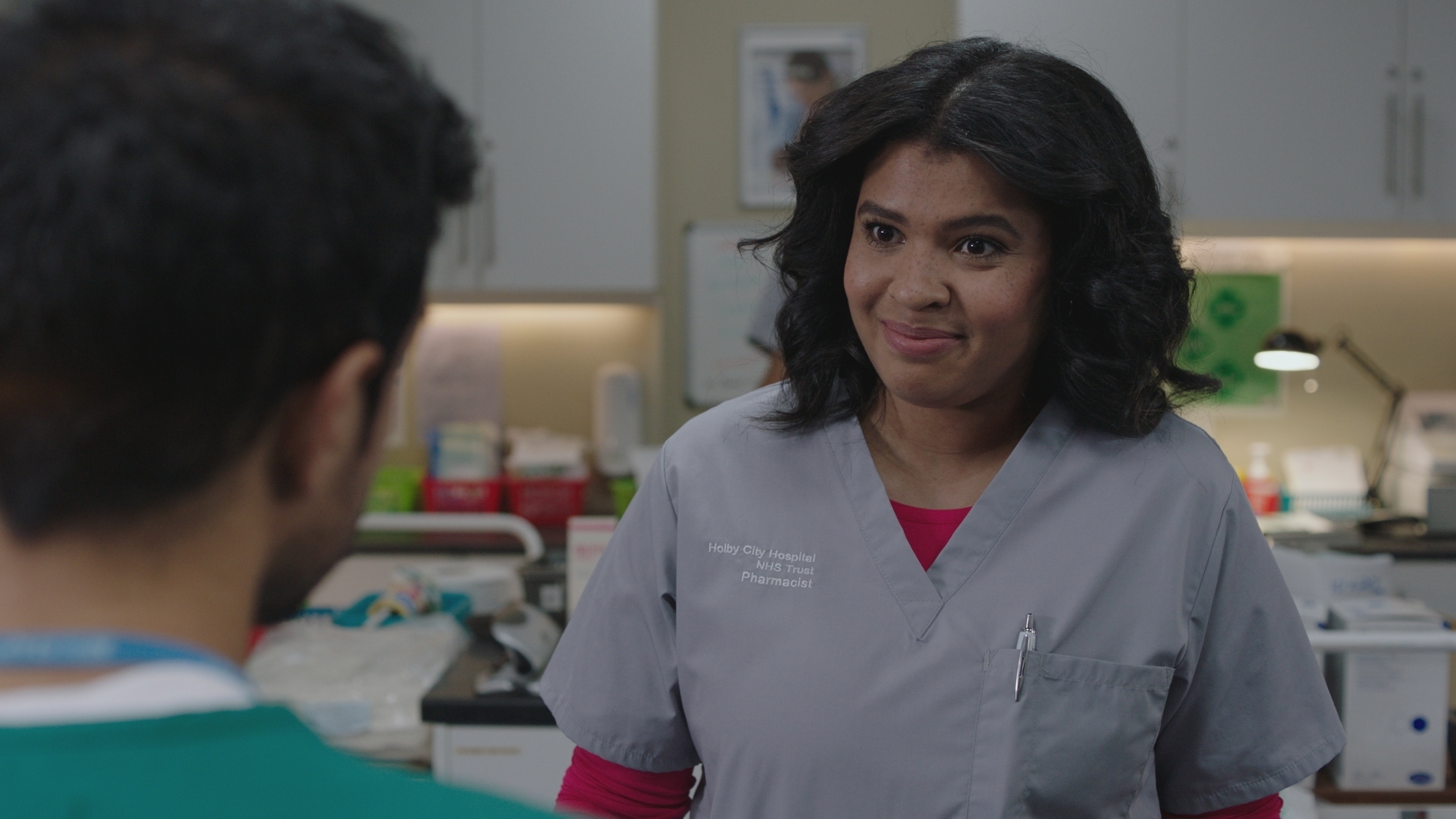 Sunny smiles at Rash when he visits her while she's working at the hospital pharmacy.