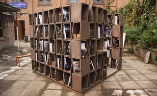 Modular, hollow ceramic blocks stacked together to form a shelving unit, displaying books