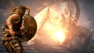 The Elder Scrolls V: Skyrim screenshot showing the an armored man wielding a shield in front of a raging dragon, holding back against the creature&#039;s fiery breath