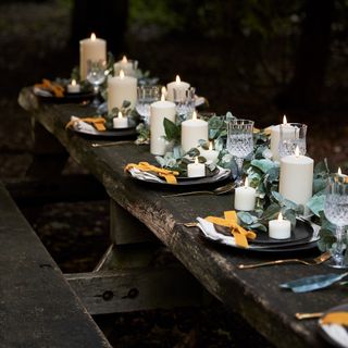 wooden outdoor table set up for a party with LED candles for decoration