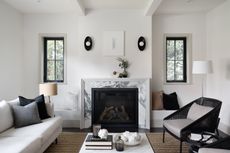 a modern living room with a marble fireplace