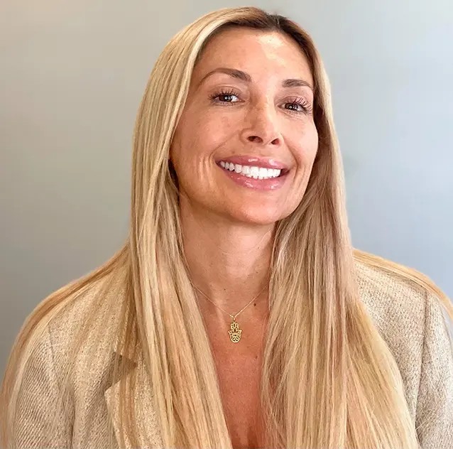 A woman with long blonde hair, Devin Graciano, smiles in her headshot.