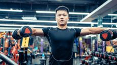 Man doing dumbbell lateral raise in gym