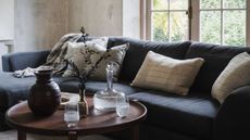 A dark navy slubby living room corner sofa with a wooden coffee table pulled close