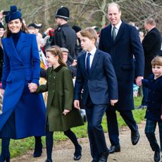 Kate Middleton, Princess Charlotte, Prince William, Prince George, Prince Louis holding hands wearing blue coats and walking to church